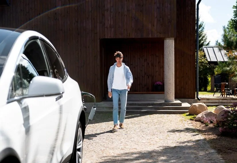 Homem, carro e garagem ao fundo